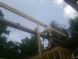 Carpenter setting a ridge beam over a new addition frame in Addyston