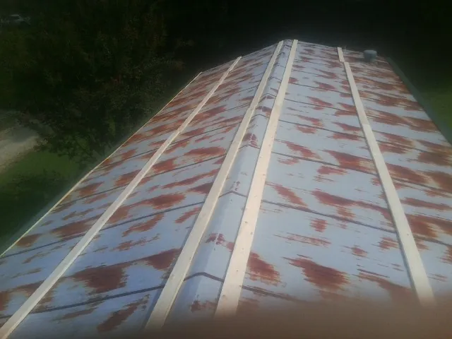 Rusted metal roof panels with new wood purlins before replacement — Storm Damage Roof Repair in Addyston by Roofing Brothers