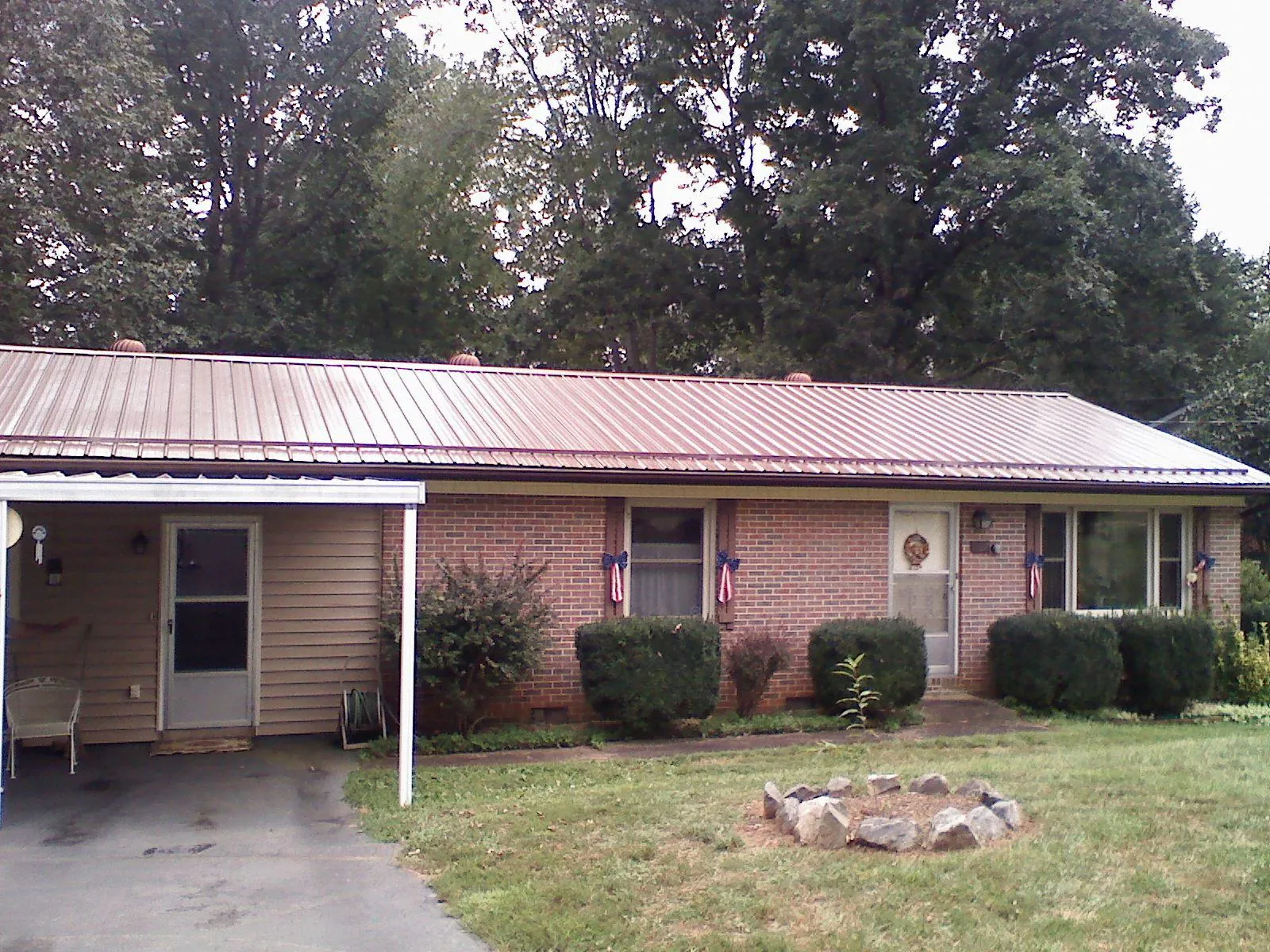 Bronze metal roof and carport on a brick ranch home — Roof Repair work by our crew in Addyston