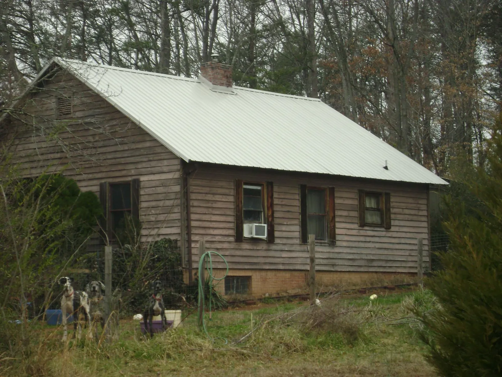 White metal roof on an old wood sided farmhouse, from a Asphalt Shingle Roof Repair job in Addyston